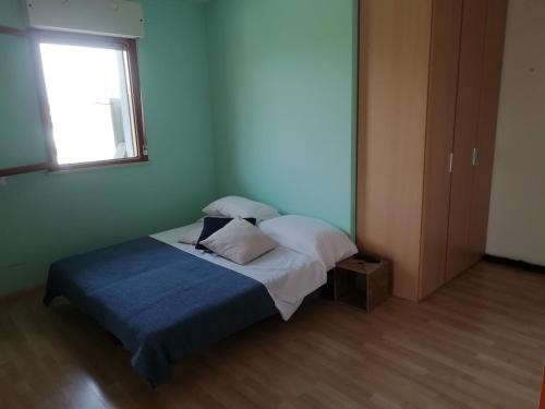 a bedroom with a bed with a blue blanket and a window at Super nice studio in amazing residence in Bibione