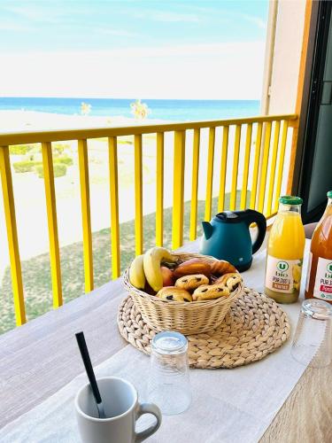 une corbeille de fruits sur une table sur un balcon dans l'établissement Escale au Sud, un appart les pieds dans l eau :), au Barcarès