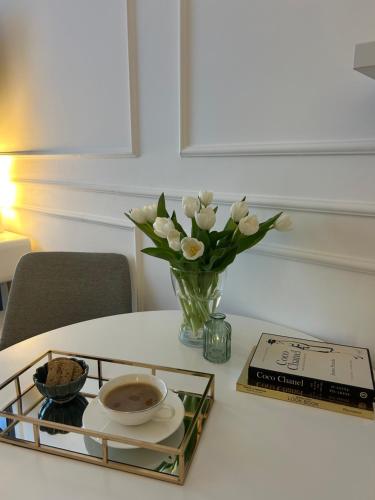 a table with a vase of flowers and a book at RED RIDING HOOD in Belgrade