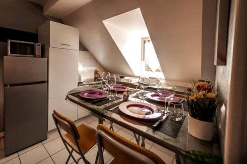 una cocina con una mesa con copas de vino. en Magnifique Duplex Atypique proche Gare Mulhouse en Mulhouse