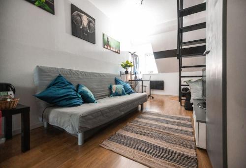 uma sala de estar com um sofá com almofadas azuis em Magnifique Duplex Atypique proche Gare Mulhouse em Mulhouse