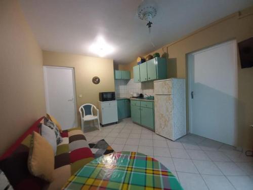 - une cuisine avec un canapé et une table dans une chambre dans l'établissement Appartement cosy avec chambre, à Marigot