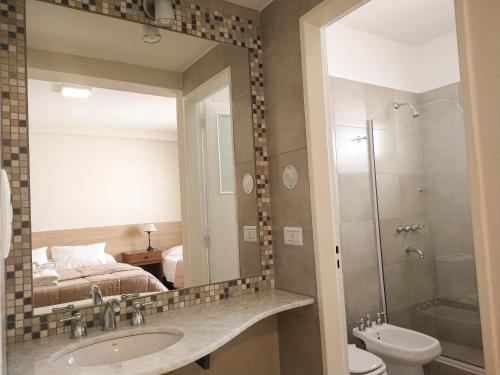 bagno con lavandino e specchio di GS Hotel a Salta