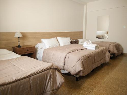 Habitación de hotel con 2 camas y espejo en GS Hotel en Salta