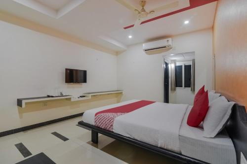 una camera da letto con un letto con cuscini rossi di Super Collection O Ms9 Guest Inn a Kurnool