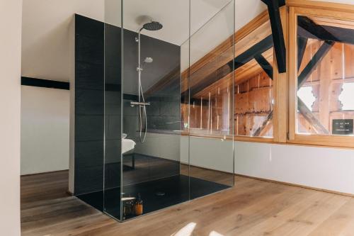 a glass shower in a bathroom with a window at Bauernchalet elbacher gütel - Exklusives Ferienhaus am Starnberger See in Eurasburg