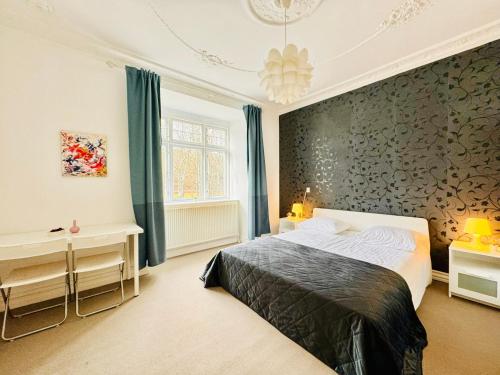 Schlafzimmer mit einem Bett und einer Wand mit blauen Vorhängen in der Unterkunft aday - Villa Firenze - 2 Bedrooms Bright Apartment in Aalborg