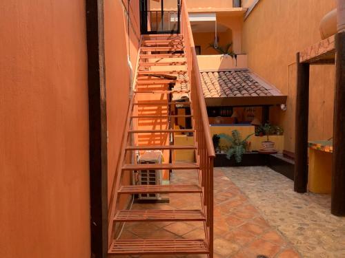 a wooden spiral staircase in a room with a hallway at Hotel Casamar Suites in Puerto Escondido