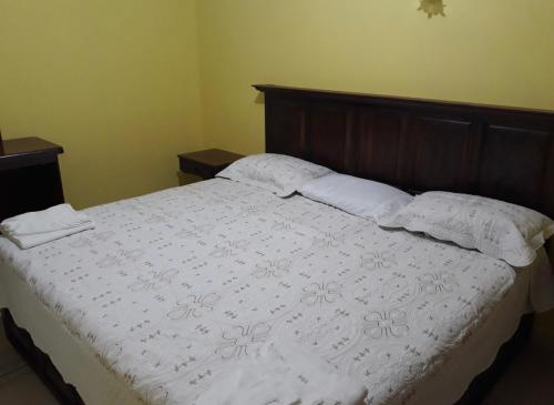 a bedroom with a large bed with white sheets and pillows at Hotel curvita in San Cristóbal