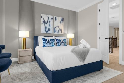 a bedroom with a bed with blue and white pillows at Elegant Disney Vacation Home on Reunion Resort in Kissimmee