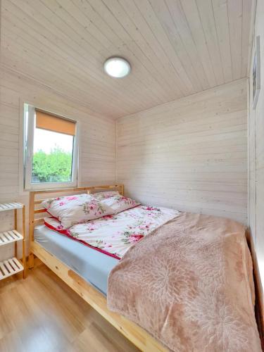 a bed in a small room with a window at Chatki u Agatki in Jezierzany