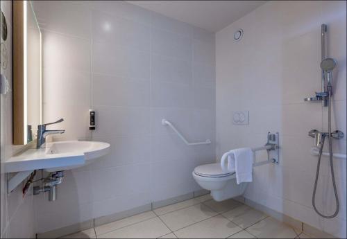 ein weißes Bad mit einem WC und einem Waschbecken in der Unterkunft B&B HOTEL CHARTRES Oceane in Chartres