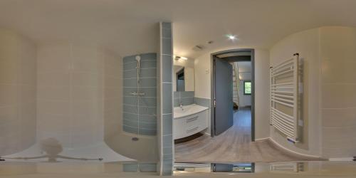 ein Badezimmer mit einer Badewanne, einem Waschbecken und einem Spiegel in der Unterkunft Moulin de Parayre in Les Vignes