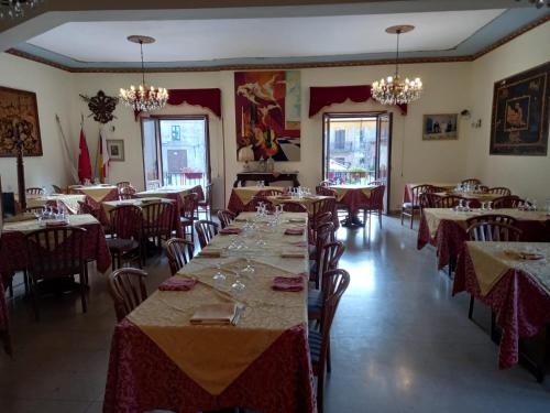 ein Esszimmer mit Tischen, Stühlen und Kronleuchtern in der Unterkunft Hotel Edelweiss in Erice