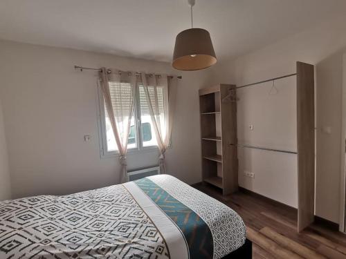 une chambre avec un lit et une fenêtre dans l'établissement Maison des fleurs d'Ajoncs, à Naujac-sur-Mer