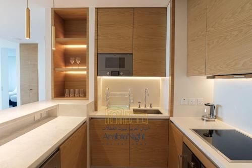 a kitchen with wooden cabinets and a sink at Arabian Nights - Oceanfront Luxurious Living at Atlantis The Royal in Dubai