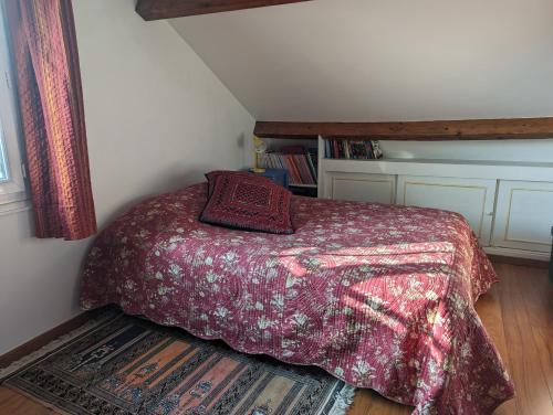 um quarto com uma cama com um edredão vermelho em Chambre dans une maison pendant les Jeux Olympiques em Rambouillet