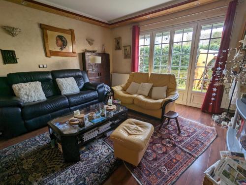 uma sala de estar com um sofá e uma mesa em Chambre dans une maison pendant les Jeux Olympiques em Rambouillet