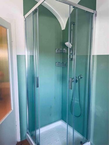 y baño con ducha y puerta de cristal. en Terrazza Bellavista Suite en Bolgheri