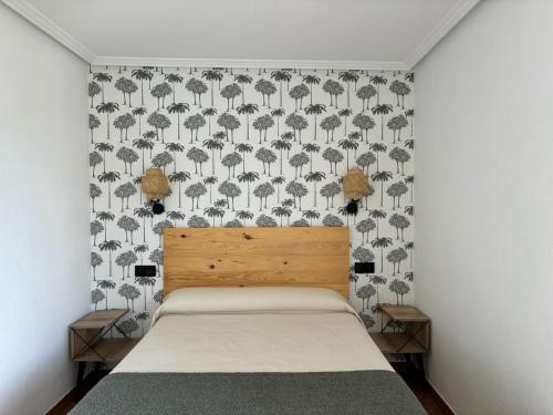 a bedroom with a bed and a wallpaper with elephants at Luarca Zabala Hotel in Luarca