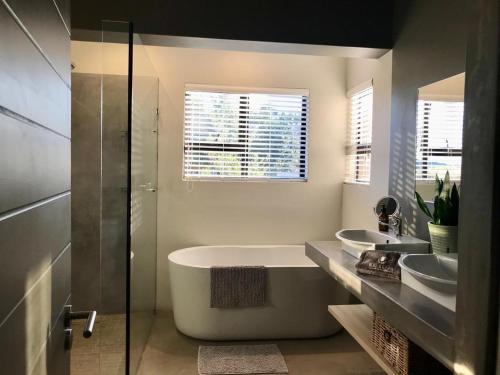 a bathroom with two sinks and a bath tub at Highland Gate Belhaven in Dullstroom