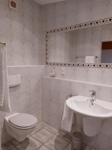 a white bathroom with a toilet and a sink at Gut Hansenhof in Düsseldorf