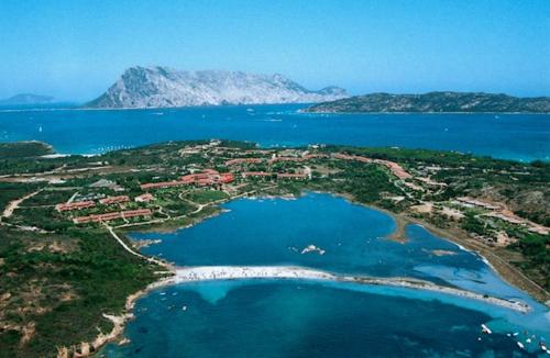 una vista aérea de una pequeña isla en el agua en Porto Coda Cavallo Salina Bamba, en Capo Coda Cavallo