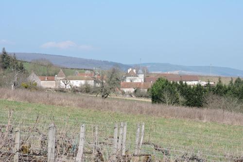 un campo con una valla y casas al fondo en GITE DU VIGNERON, en Chassey-Le-Camp