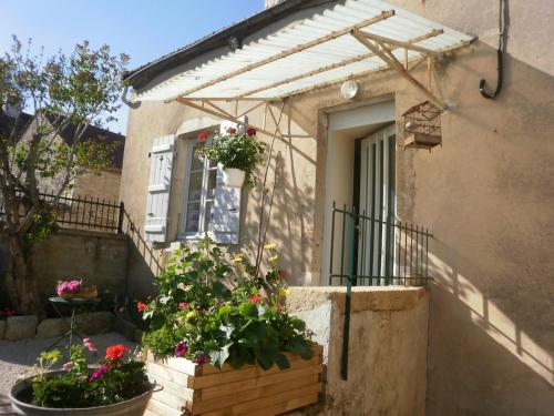une maison avec des fleurs devant une fenêtre dans l'établissement GITE DU VIGNERON, à Chassey-Le-Camp