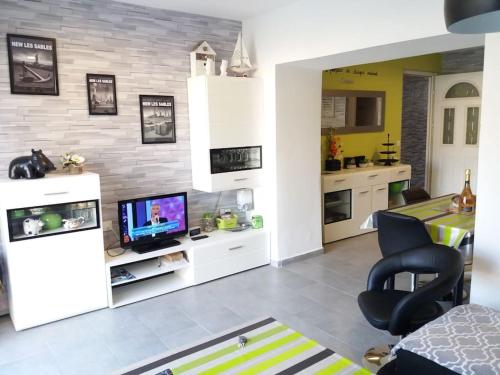 Il comprend un salon avec une télévision et une cuisine. dans l'établissement Maison de 120 m², divisée en 2 appartements indépendants, à Les Sables-dʼOlonne