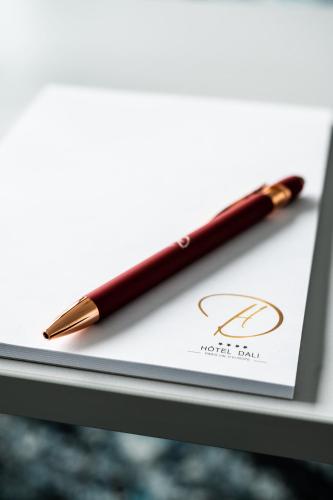 a red pen sitting on top of a piece of paper at Hotel Dali Val d'Europe, Tapestry Collection by Hilton in Chanteloup-en-Brie