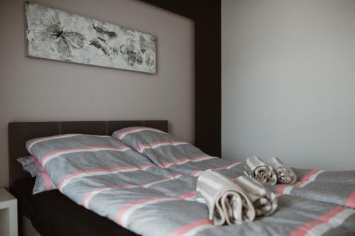 Una cama con sábanas a rayas y zapatos. en Apartament Giżycko plaża, blisko centrum, en Giżycko