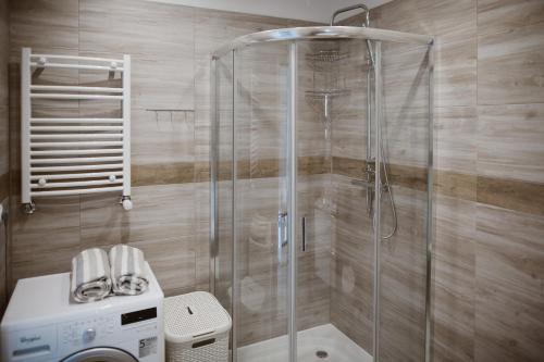 W łazience znajduje się prysznic i pralka. w obiekcie Apartament Giżycko plaża, blisko centrum w mieście Giżycko