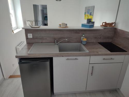 a kitchen counter with a sink and a dishwasher at le Cozy Bayeusain in Bayeux