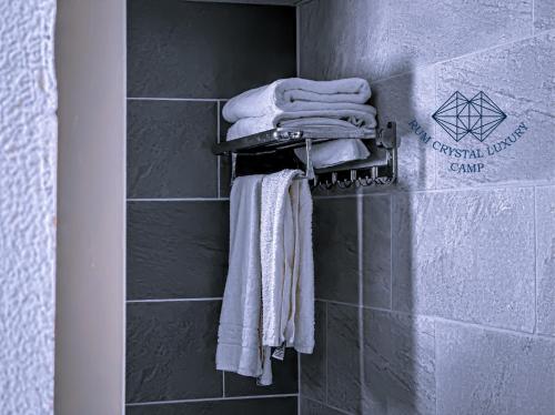 a group of towels hanging on a wall in a bathroom at Rum Crystal Luxury Camp in Wadi Rum