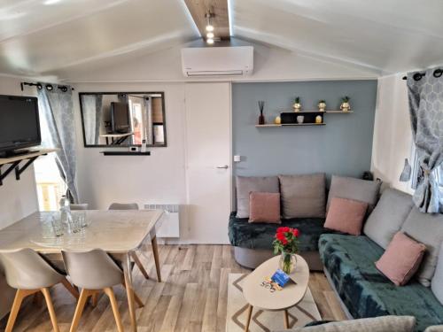 a living room with a couch and a table at Camping Mar Estang in Canet-en-Roussillon