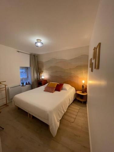 une chambre avec un grand lit blanc dans une pièce dans l'établissement Maison de village Cœur Andéol, à Saint-Andéol-le-Château