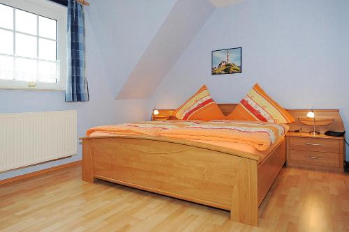 a bedroom with a wooden bed and a window at Ferienwohnung Lena in Stedesdorf bei Esens an der Nordseeküste in Ostfriesland in Stedesdorf