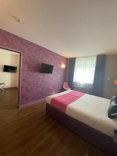 a hotel room with a bed and a purple wall at The Originals City - Hôtel Saint-Martial, Limoges Centre in Limoges