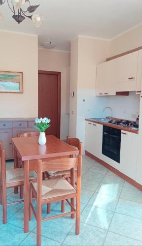 una cocina con una mesa de madera con un jarrón de flores. en Sweet home, en San Massimo
