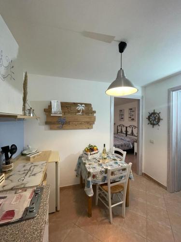 a kitchen and dining room with a table and chairs at Le Palme Holidays in Palmadula