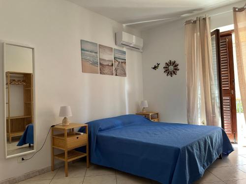 una camera con letto blu e specchio di Casa Maruzzella a Città di Lipari