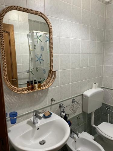 bagno con lavandino, specchio e servizi igienici di Casa Maruzzella a Città di Lipari