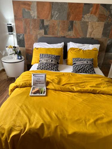 ein gelbes Bett mit einem Buch darüber in der Unterkunft Bienvenue à la Marine de St Benoit 1 in Saint-Benoît