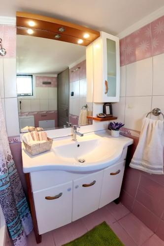 a bathroom with a sink and a large mirror at Old Harbour Aroura 2BR Home in Spetses