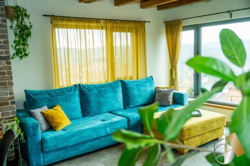 a blue couch in a living room with windows at Studio54 Stunning View plus Free Parking in Veliko Tŭrnovo
