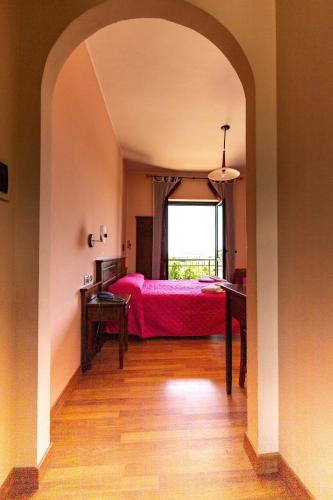 a bedroom with a red bed and a window at Hotel Pina Ristorante in Isola del Gran Sasso dʼItalia