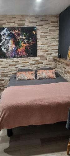 une chambre avec un lit avec un tableau sur le mur dans l'établissement appartement cosy, à Feigères