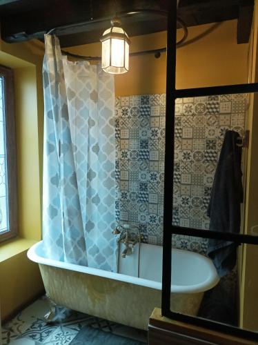 une salle de bain avec une baignoire et un lavabo dans l'établissement Une nuit au manoir Thiers mode hanté possible gratuitement, à Thiers