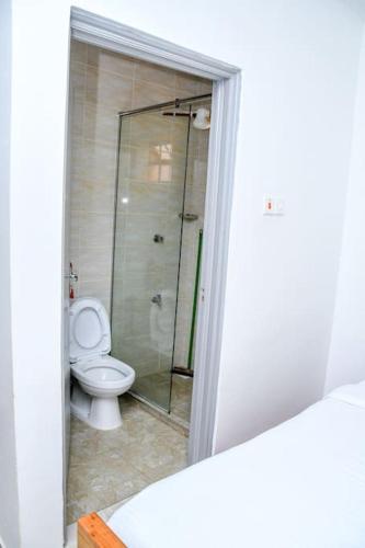 a bathroom with a toilet and a glass shower at Familia@HeArt in Kakamega